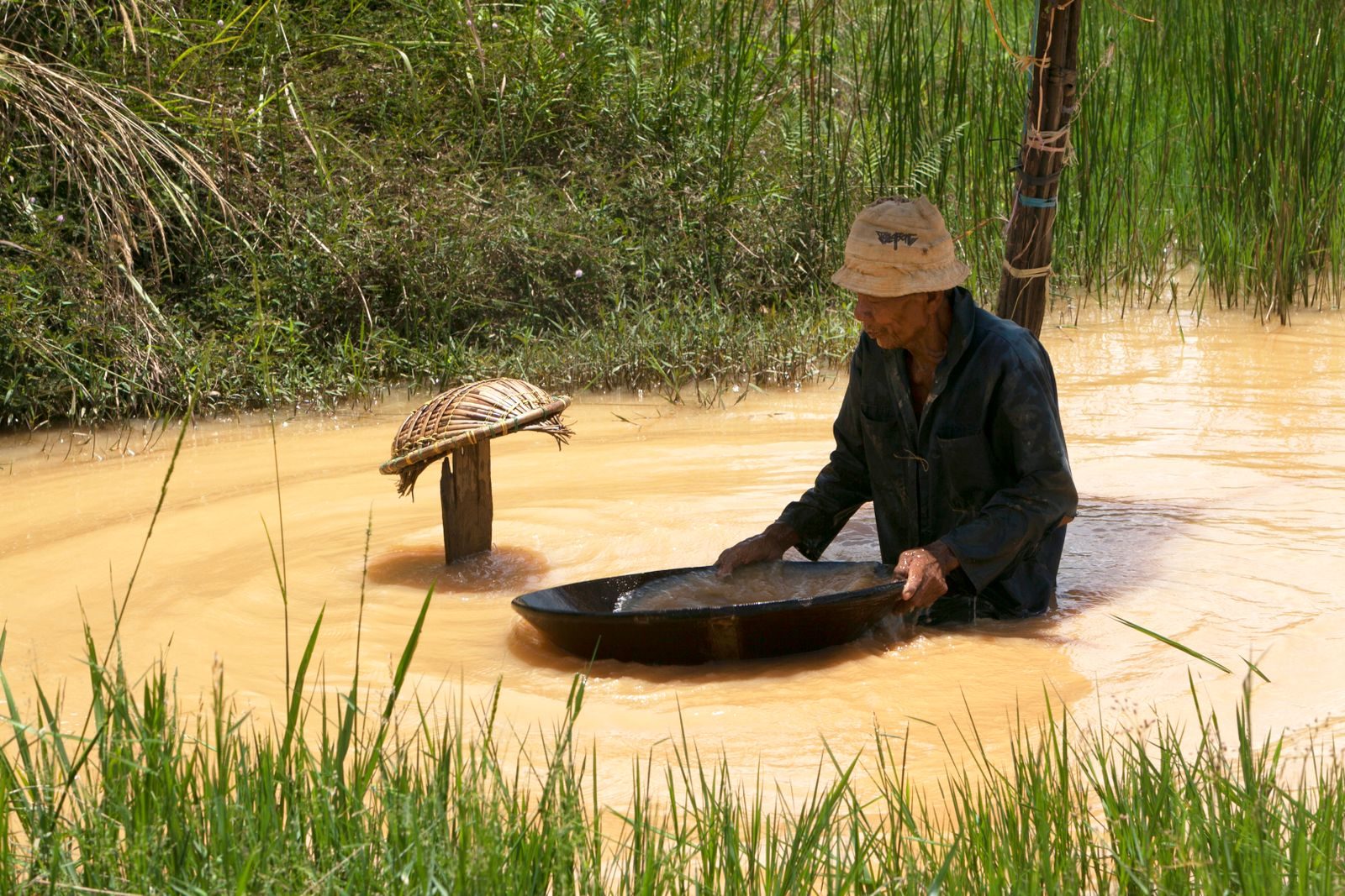Mineur artisanal pratiquant l'orpaillage dans un cours d'eau